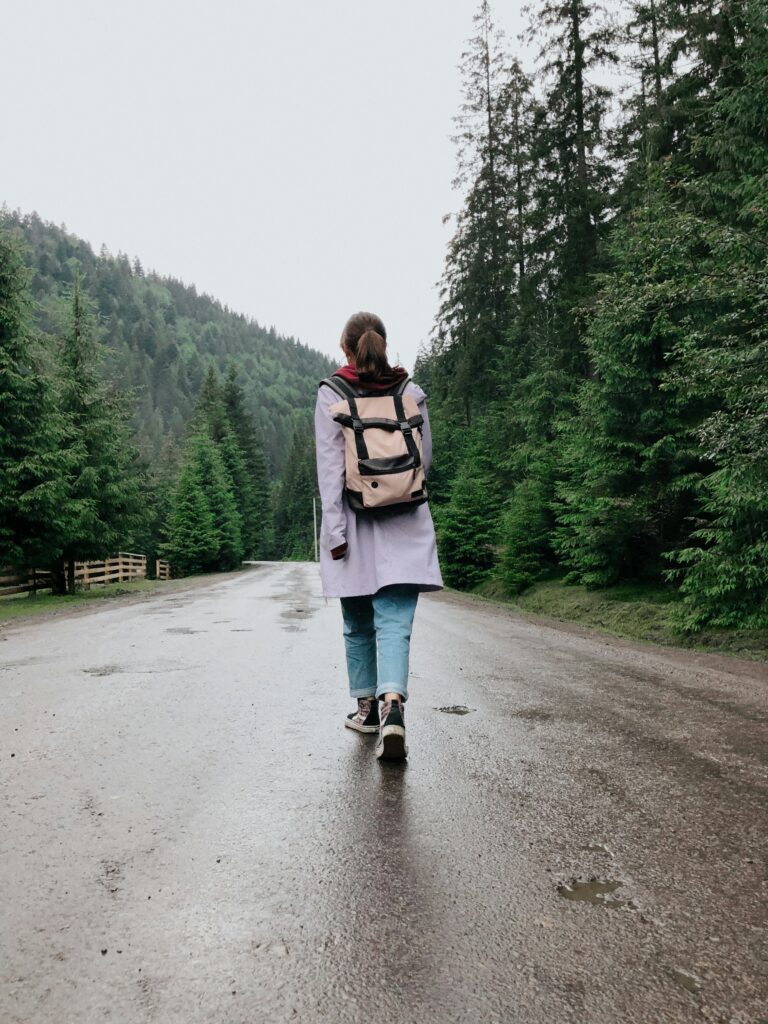Eine Frau läuft durch den Wald, Sie trägt einen Rucksack